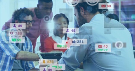 Reviewing team pointing at laptop screen in office meeting room, with floating notification icons