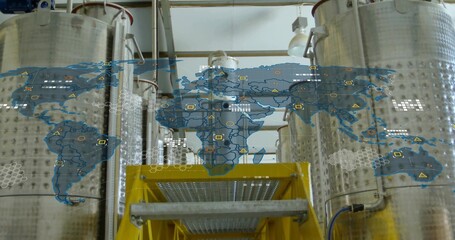 Steel tanks standing in brewery, with digital world map overlay, platform staircase and piping