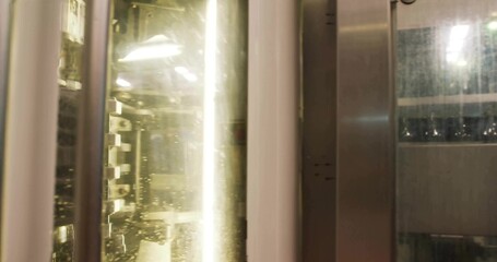Showing chamber in enclosure with droplet-covered glass panel, bars, rails and fluorescent tube