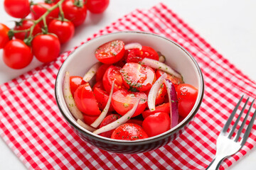 Bowl of fresh tomato salad with red onion on white background, closeup