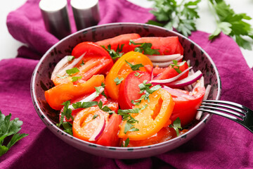 Bowl of fresh tomato salad with red onion and parsley on white background, closeup