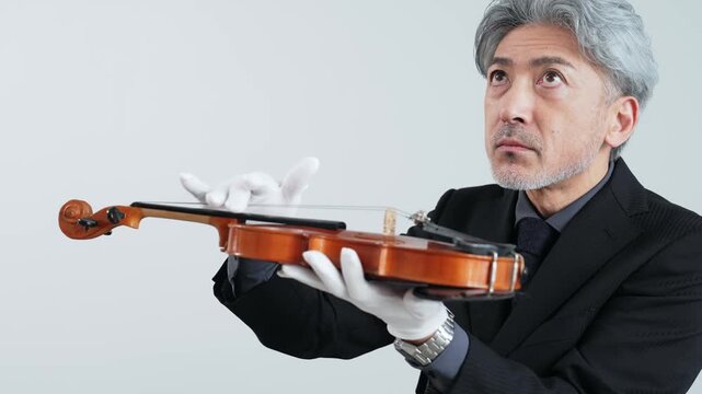 バイオリンを確認するミドルエイジ男性