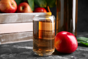 Glass of fresh apple cider on dark background