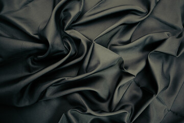 Obraz premium Dark Fabric with Elegant Folds. Abstract background of black silk fabric with soft, wavy folds.
