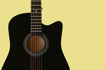 Modern black guitar on green background, closeup