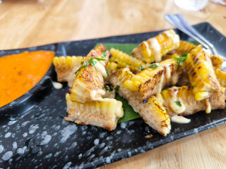 Grilled Corn with Sauce on black Plate