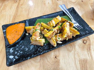 Grilled Corn with Sauce on black Plate