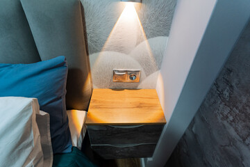 A nightstand that is situated in a cozy bedroom, adorned with a lamp providing soft illumination on...