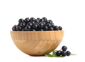 Wooden bowl with fresh black currants on white background