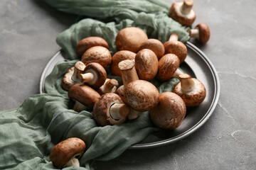 Plate with fresh raw mushrooms on grey background, closeup