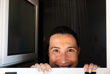 Smiling woman in the shower, feeling refreshed and relaxed