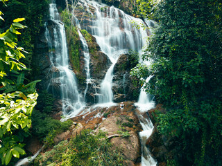 Aerial view of a beautiful waterfall in the middle of a forest in the pristine nature of the forest.