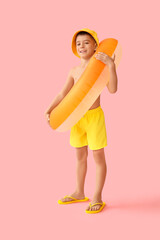 Cute little boy with bucket hat and inflatable ring on pink background