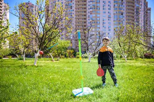 Happy boy is playing tetherball swing ball game in summer camping. Happy leisure healthy active time outdoors concept