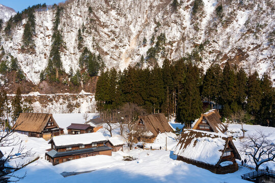 Overlooking the snowy Suganuma gassho-zukuri village, nestled beneath a steep, forested mountain in Japan's Gokayama region. Nanto, Toyama, Japan.