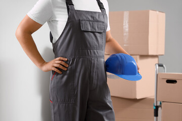 Male loader with hardhat and cardboard boxes in warehouse