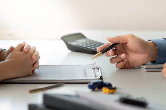 Financial Consultation. Professional discussing car insurance options with client.
