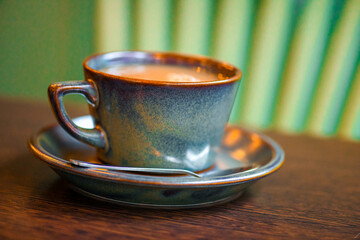Vintage coffee cup with saucer and spoon on wooden table
