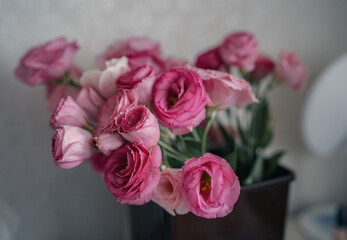 Bouquet of beautiful pink eustoma flowers on the table in the room. Flowers close-up.