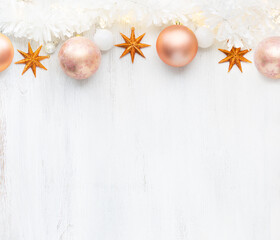 Christmas and New Year background with holiday decorations.
Garland, tinsel, Сhristmas balls  and stars on old wooden shabby background with empty space for text.