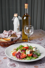 Delicious salad and wine with bread and angel figurine.