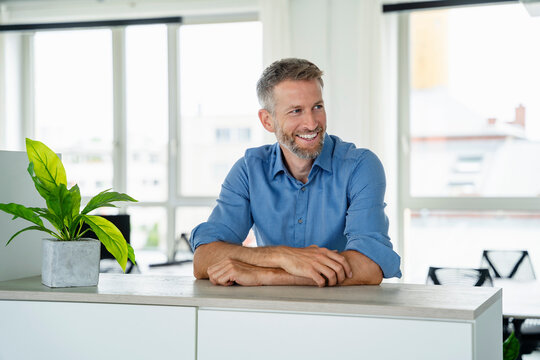 Confident businessman smiling in modern office setting