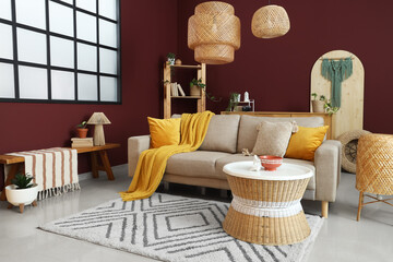 Interior of stylish living room with cozy grey sofa, coffee table and wicker lamps