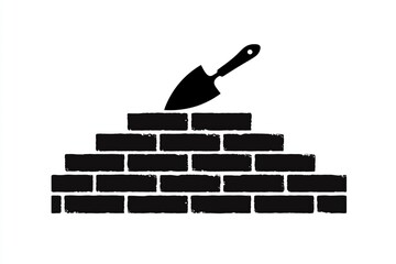 Brick wall construction with masonry trowel resting on top, symbolizing building and design process in construction projects