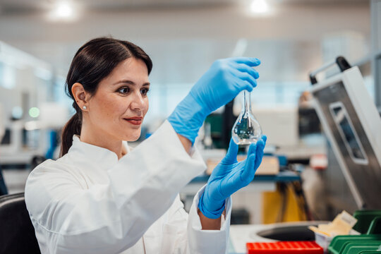 Scientist in laboratory analyzing liquid in clean room environment