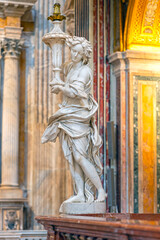 Angels made of Carrara marble at the right and left ends of the balustrade that separates the choir area in the Church of the Girolamini in Naples.
