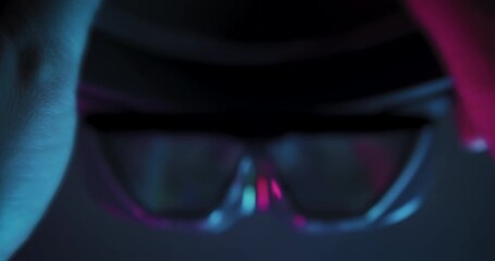Futuristic AR glasses with darkened lenses and no active display, indicating system shutdown or inactive mode, contrasted by ambient neon lights.