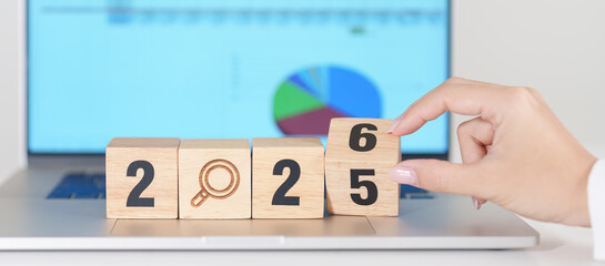 2025 end year to Happy New Year 2026 block with magnifying glass icon against laptop computer. SEO,...