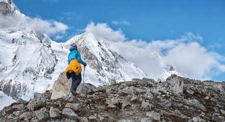 Beautiful panoramic view of walking hiker with mountains in background early in morning in Manaslu National Park in Himalayas, Nepal.