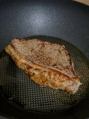 Seared steak marbled beef cast iron pan sizzle browning oil home cooking close up savory aroma dinner