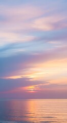 Obraz premium Dreamy aesthetic photo of pastel-colored clouds at sunset above a quiet sea