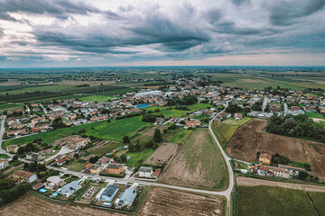Po valley countryside with dark clouds approaching: aerial view of rural italy