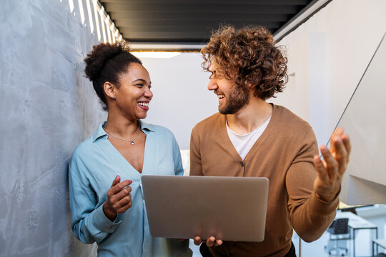 Team collaboration and digital transformation with colleagues sharing ideas at a laptop in office