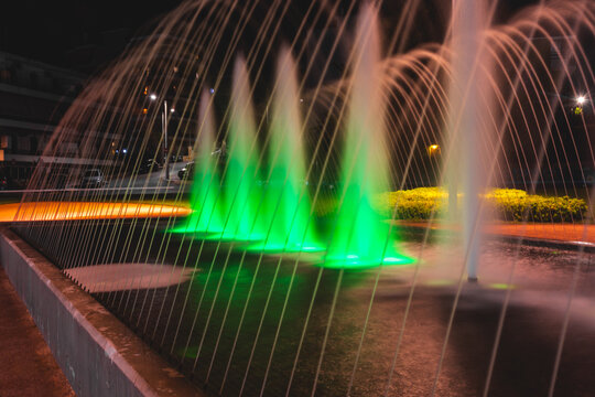 Night fountain with green and orange lights in Ilion, Attica, Greece.