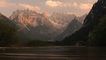 sunset in the mountains over the lake durrense in dolomitas