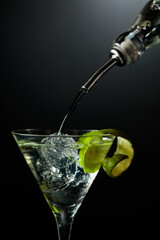 Vodka or gin is poured into a glass with ice.