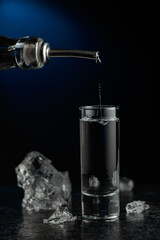 Crystal clear vodka or gin being poured into a glass.