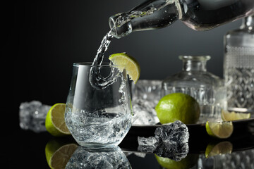 Vodka or gin is poured into a glass with ice.