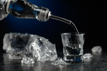 Crystal clear vodka or gin being poured into a glass.