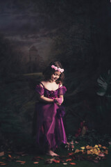 A young girl dressed as a fairy in a forest setting.