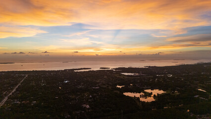 Drone aerial photo of Tampa at sunset with glowing orange and golden clouds above the city and waterfront, highlighting the dramatic atmosphere of Florida’s Gulf Coast urban landscape.