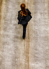 A woman in a black suit walks on a waterfall.