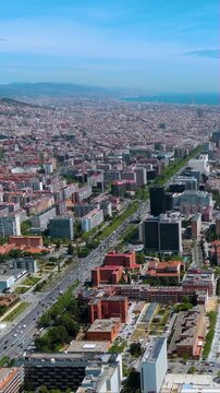 4K vertical drone video of Barcelona&rsquo;s skyline along Avinguda Diagonal toward the Mediterranean - Eixample grid, towers and traffic lines, perfect for mobile reels, travel and urban business stories.