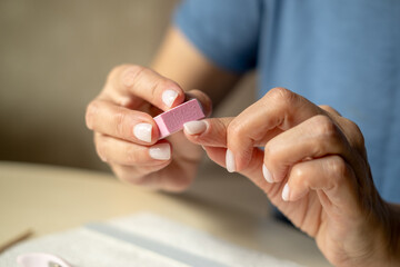 Nail care at home, close-up manicure. Using cuticle nippers, a nail file, a sanding pad, a brush and an orange stick.