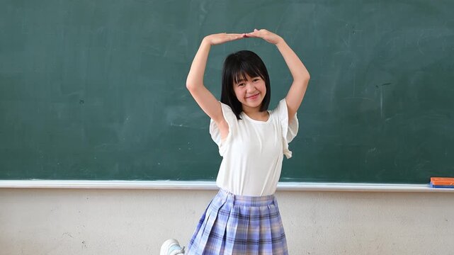 クイズに答える女子学生　学校の教室で○✕を出す教育イメージ