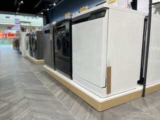 Modern dishwashers and washing machines lined up in the appliance store.